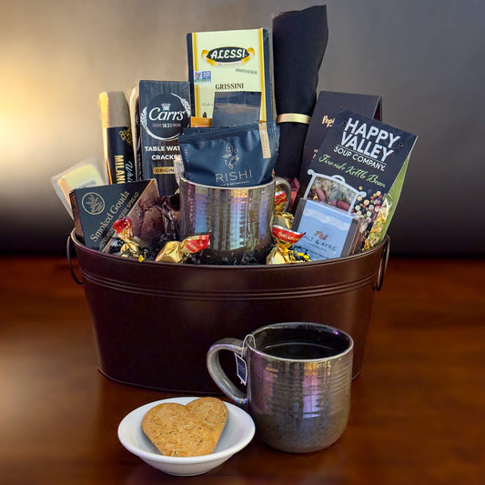 Gift basket with coffee and snacks on a wooden surface